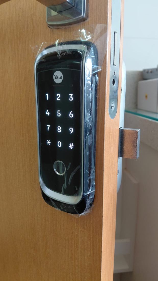 Fechadura digital Yale com teclado numérico em porta de madeira clara