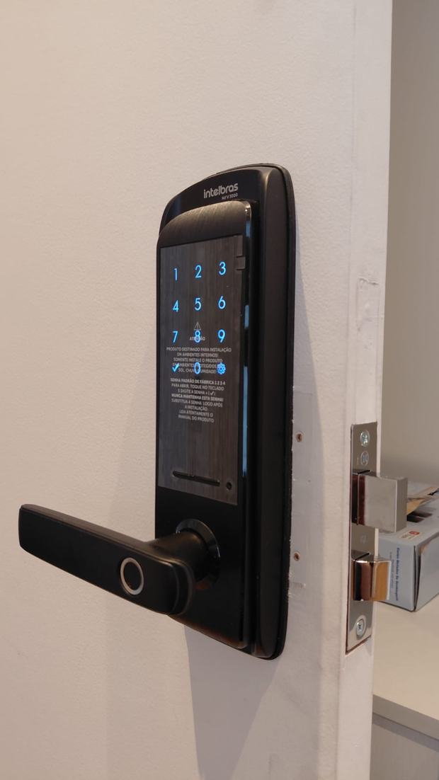 Fechadura digital escura com teclado iluminado em porta clara