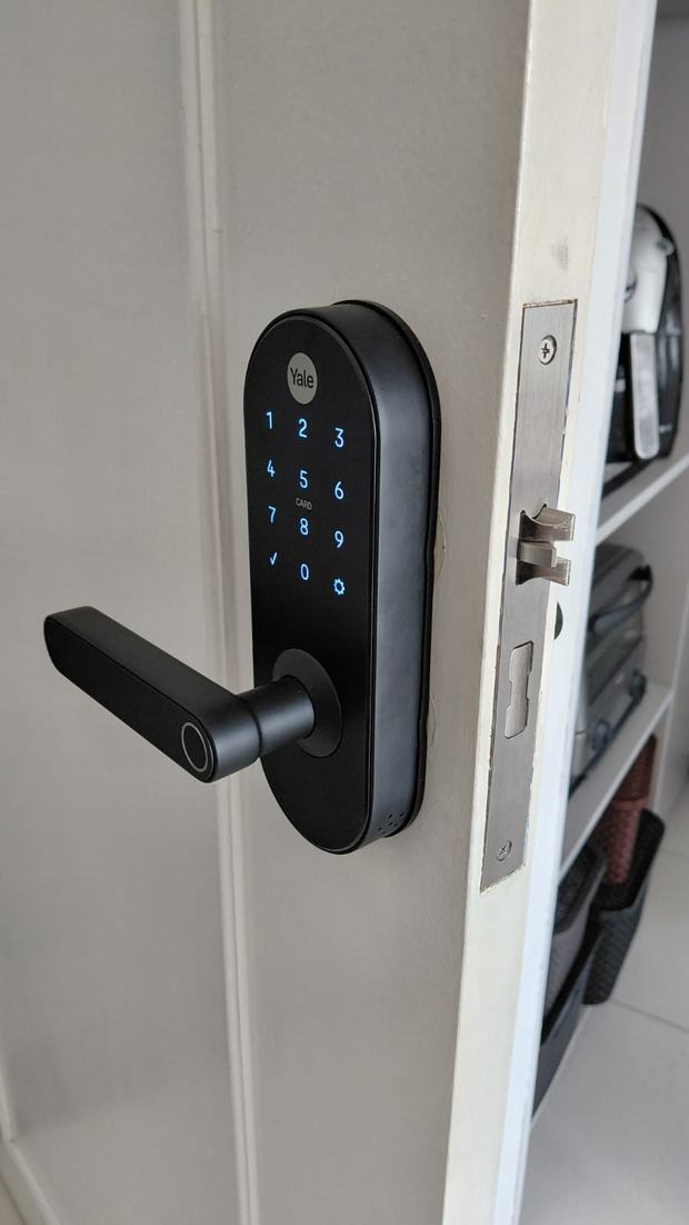 Fechadura digital escura instalada em porta branca