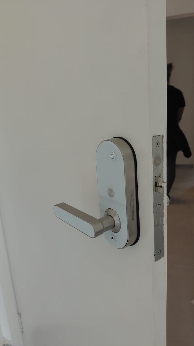 Fechadura digital prateada com maçaneta em porta branca