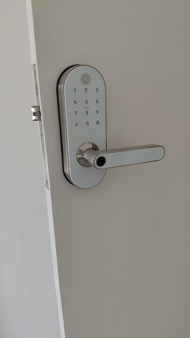 Fechadura digital prateada com teclado numérico em porta branca