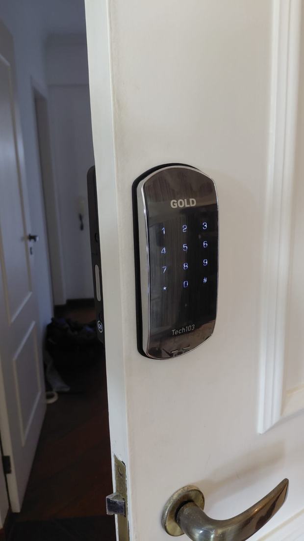 Fechadura digital escovada em porta branca de apartamento